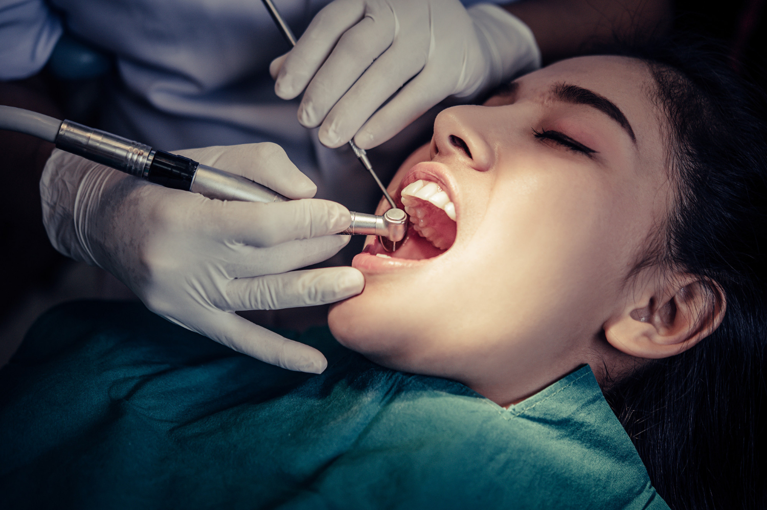 doctor examining female patient mouth